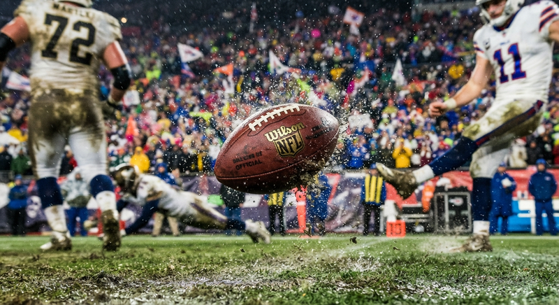 Football Frozen Mid Air with Water Droplets